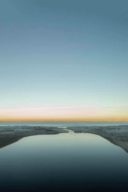 Photo scenic view of sea against clear sky during sunset