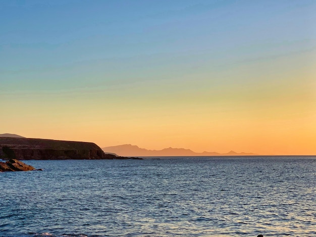 Scenic view of sea against clear sky during sunset