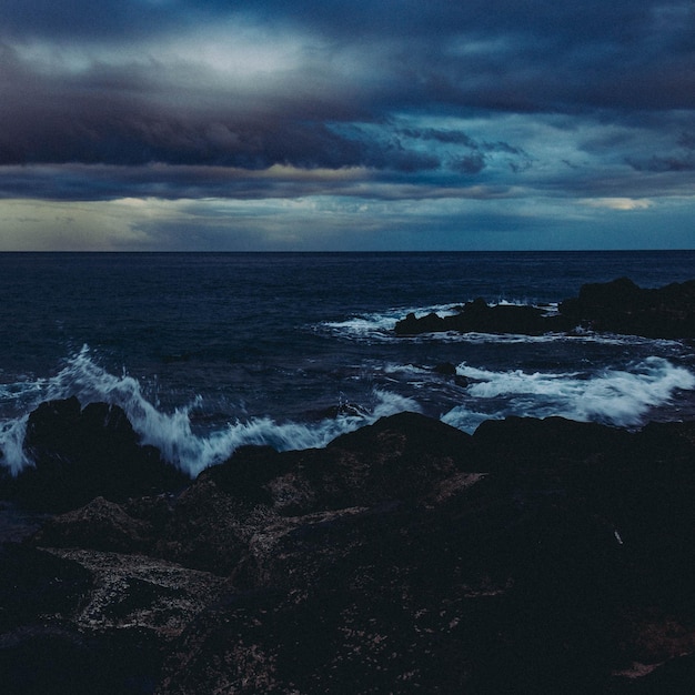 Photo scenic view of sea against cloudy sky