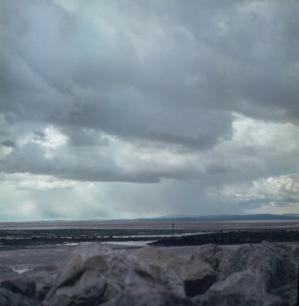 Photo scenic view of sea against cloudy sky