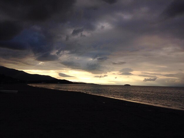 Photo scenic view of sea against cloudy sky