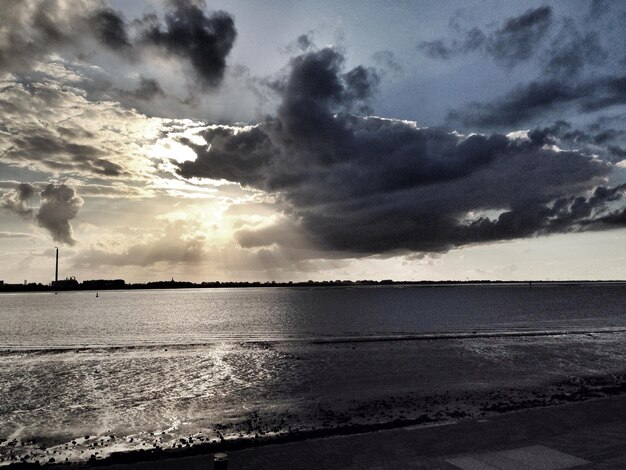 Photo scenic view of sea against cloudy sky