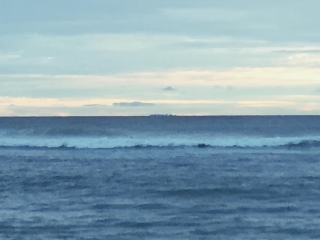 Photo scenic view of sea against cloudy sky