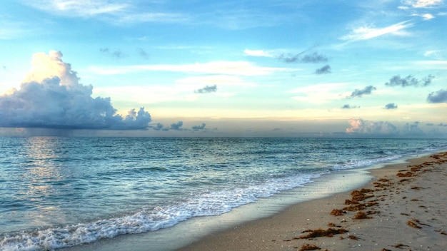 Photo scenic view of sea against cloudy sky