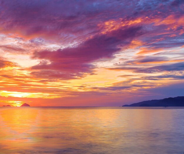 Photo scenic view of sea against dramatic sky during sunset