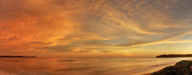 Scenic view of sea against dramatic sky during sunset