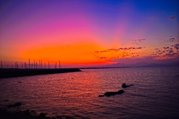 Scenic view of sea against dramatic sky during sunset