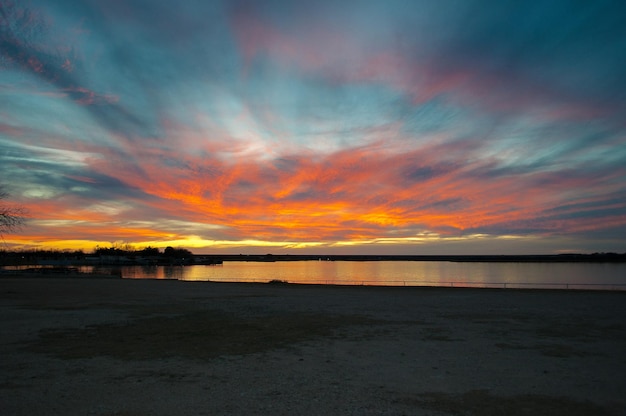 Photo scenic view of sea against dramatic sky during sunset