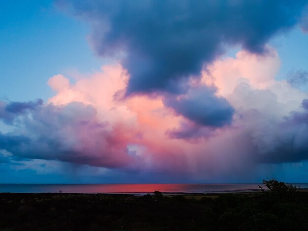 Scenic view of sea against dramatic sky during sunset