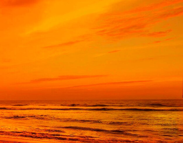 Scenic view of sea against dramatic sky during sunset