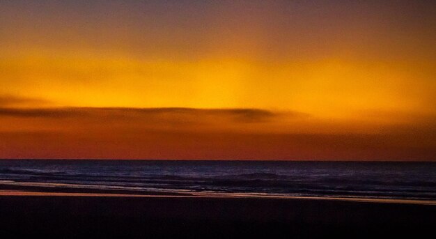 Scenic view of sea against dramatic sky during sunset