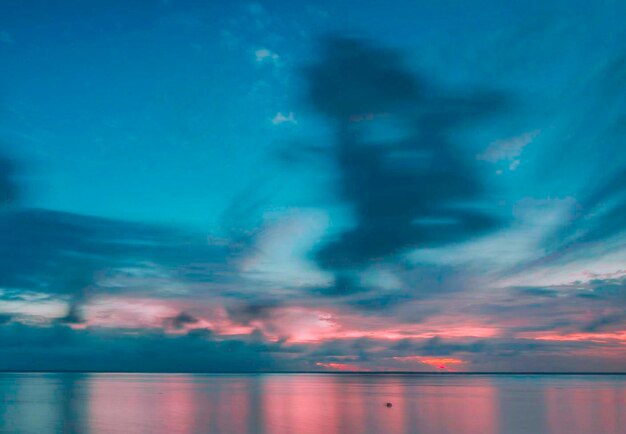 Photo scenic view of sea against dramatic sky during sunset