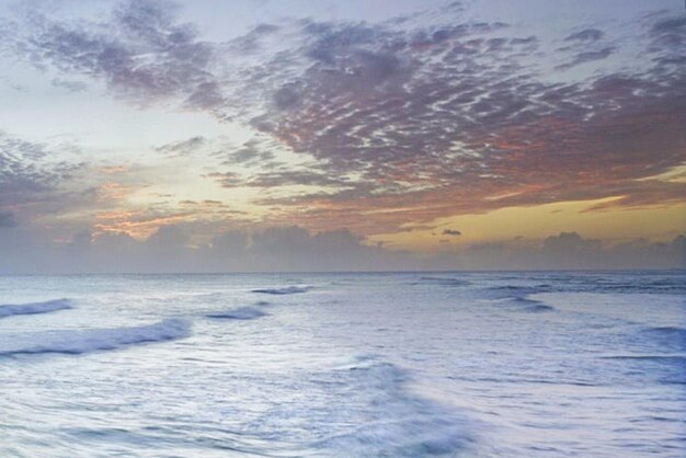 Scenic view of sea against dramatic sky during sunset