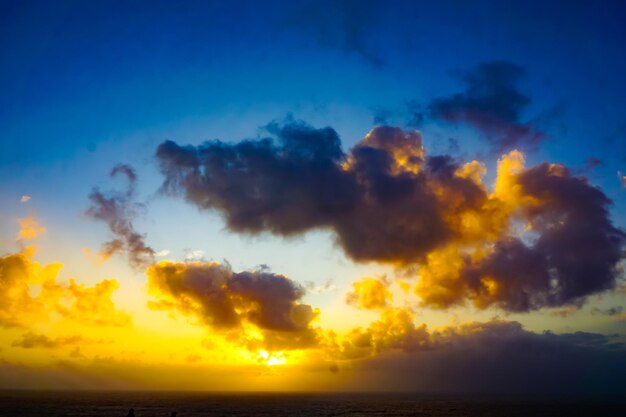 Scenic view of sea against dramatic sky during sunset