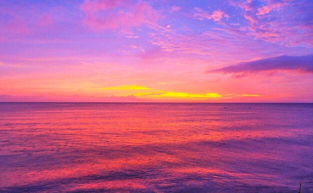 Scenic view of sea against dramatic sky during sunset