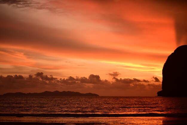 Scenic view of sea against dramatic sky during sunset