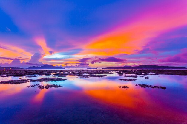 Photo scenic view of sea against dramatic sky during sunset