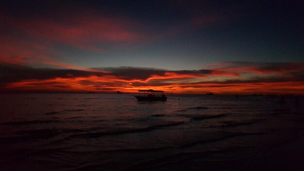 Photo scenic view of sea against dramatic sky during sunset