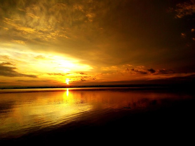 Scenic view of sea against dramatic sky during sunset