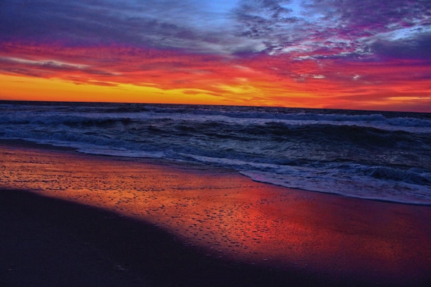 Scenic view of sea against dramatic sky during sunset