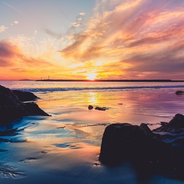 Photo scenic view of sea against dramatic sky