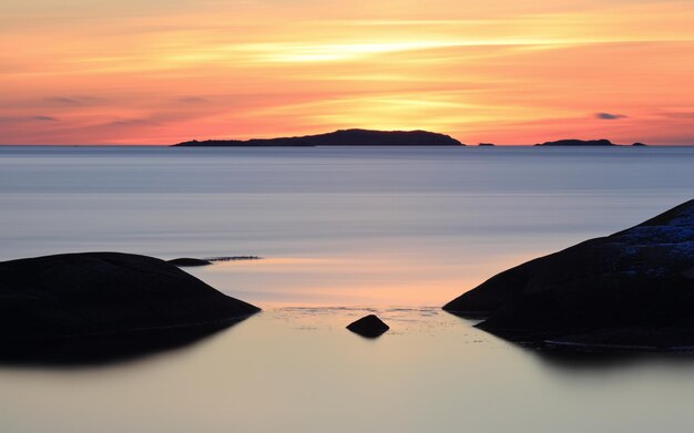 Scenic view of sea against orange sky