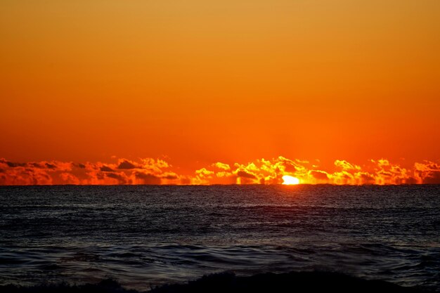 Scenic view of sea against orange sky