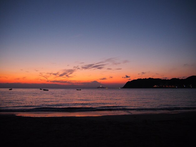 Photo scenic view of sea against orange sky