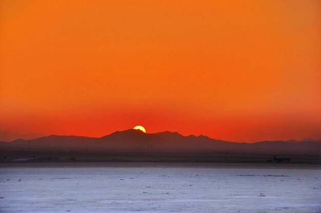 Photo scenic view of sea against orange sky