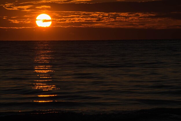 Photo scenic view of sea against orange sky