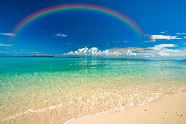 Scenic view of sea against rainbow in sky