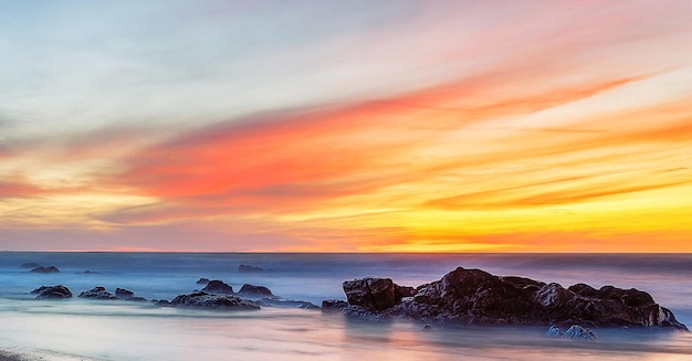 Photo scenic view of sea against romantic sky at sunset