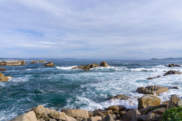 Foto vista panoramica del mare contro il cielo pietre scure passeggiata a san vicente do mar o bosco