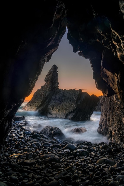 Vista panoramica del mare contro il cielo durante l'alba scattata in una grotta