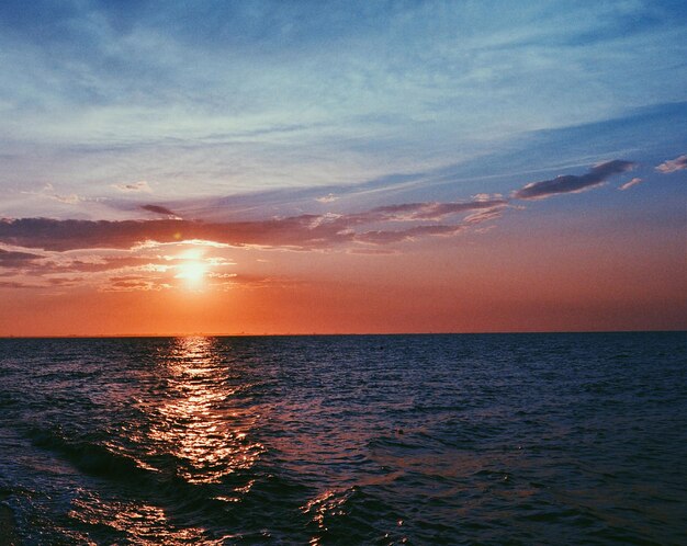 Photo scenic view of sea against sky during sunset