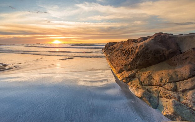 Photo scenic view of sea against sky during sunset