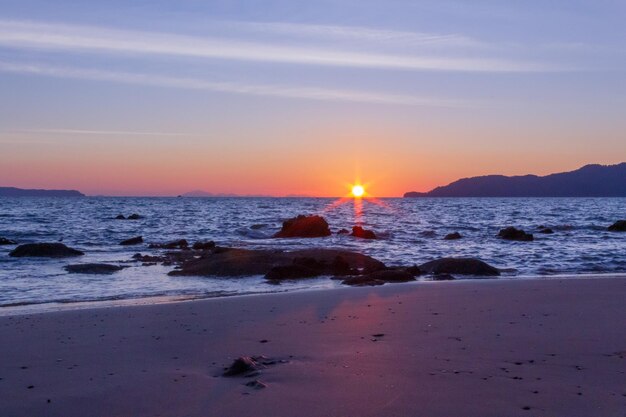 Photo scenic view of sea against sky during sunset