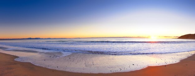 Photo scenic view of sea against sky during sunset