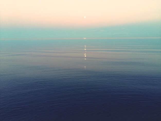 Photo scenic view of sea against sky during sunset