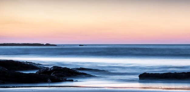 Photo scenic view of sea against sky during sunset