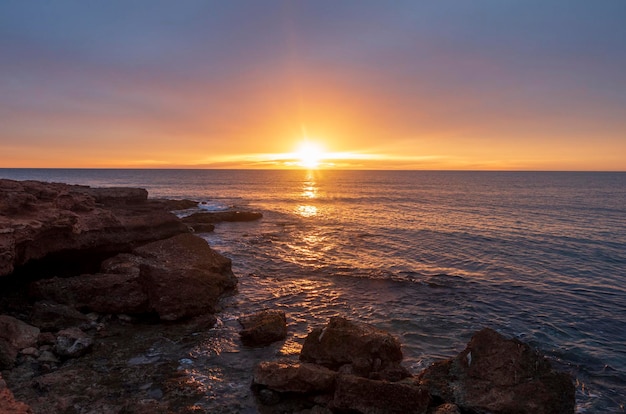 Photo scenic view of sea against sky during sunset