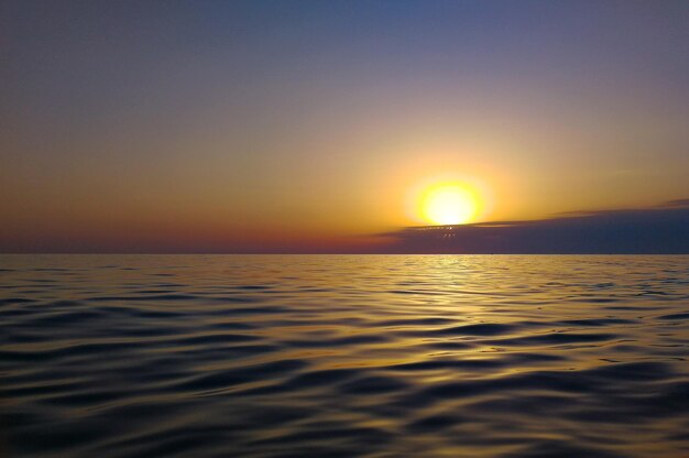 Photo scenic view of sea against sky during sunset