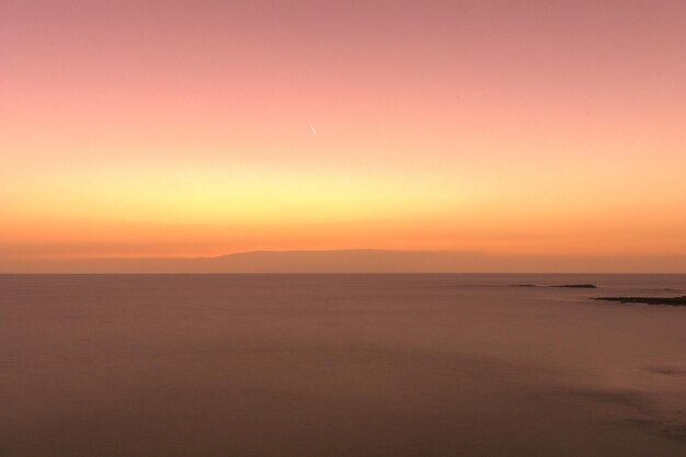 Photo scenic view of sea against sky during sunset