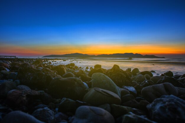 Photo scenic view of sea against sky during sunset