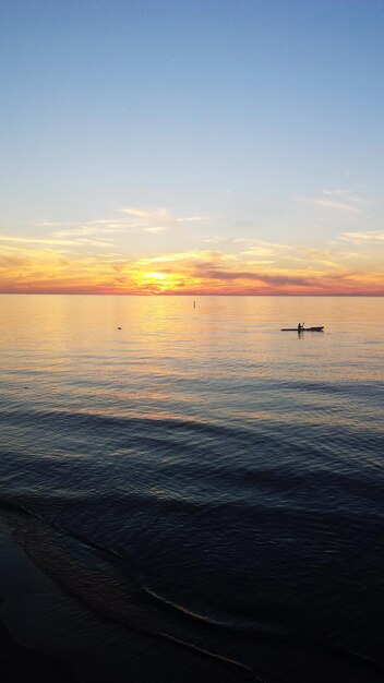 Photo scenic view of sea against sky during sunset