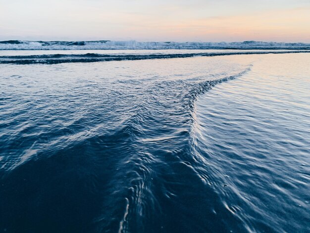 Photo scenic view of sea against sky during sunset