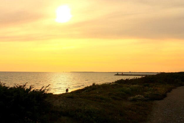 Photo scenic view of sea against sky during sunset