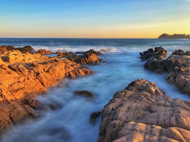 Photo scenic view of sea against sky during sunset