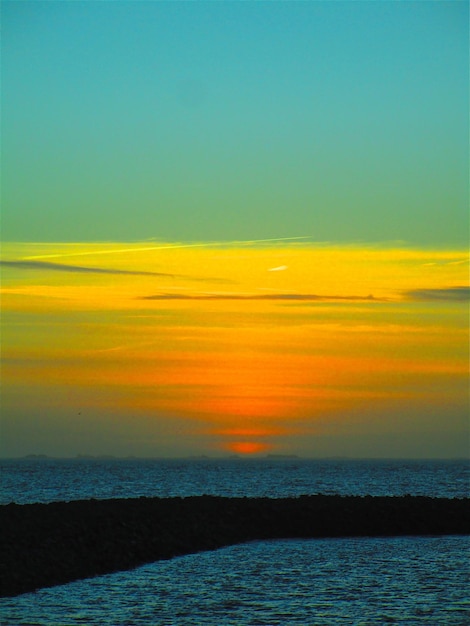 Photo scenic view of sea against sky during sunset