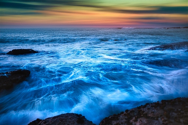 Photo scenic view of sea against sky during sunset